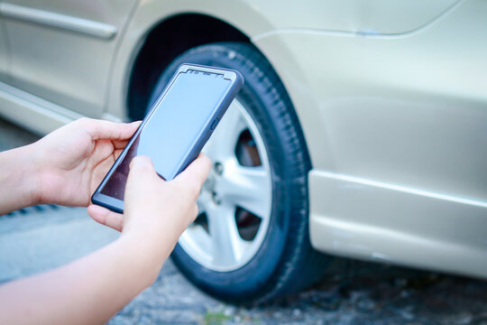 Car insurance concept. A woman driving an accident uses a smartphone to take a picture of the car. transportation