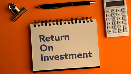 There is notebook with the word Return On Investment. It is as an eye-catching image.