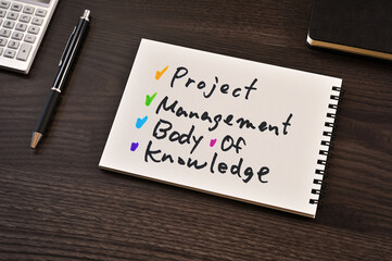There is notebook with the word Project Management Body of Knowledge. It is as an eye-catching image.