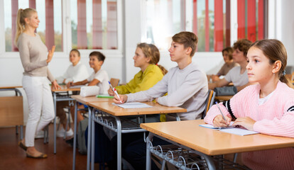 Fototapeta premium Young boys and girls studying in classroom during lesson in school.