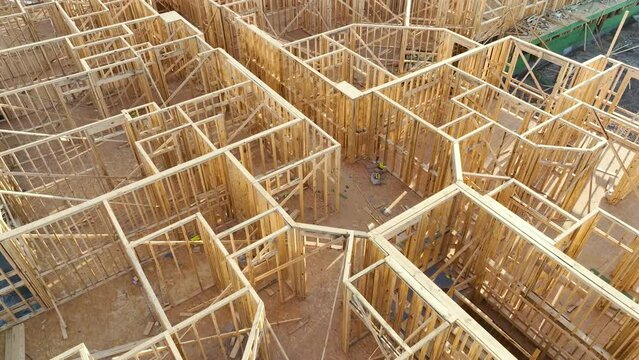 View from above of unfinished frame of apartment condo with wooden roof beams under construction. Development of residential housing in US suburbs. Real estate market in the USA