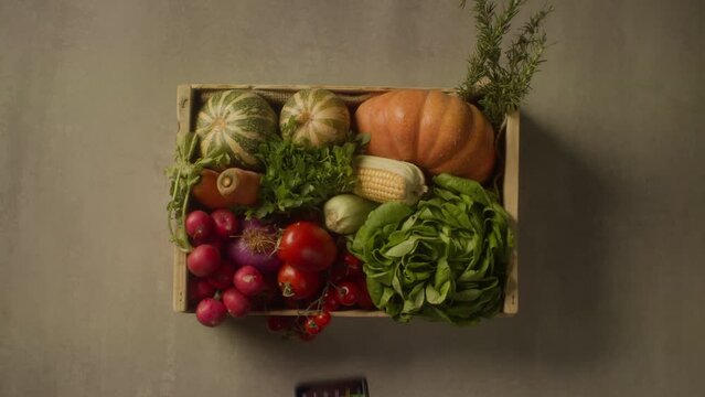 a person taking a photo of a basket, full of vegetables, with a smartphone