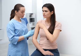 Doctor giving hepatitis vaccine to patient in clinic