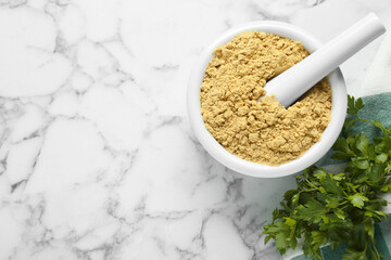 Mortar with aromatic mustard powder and parsley on white marble table, flat lay. Space for text