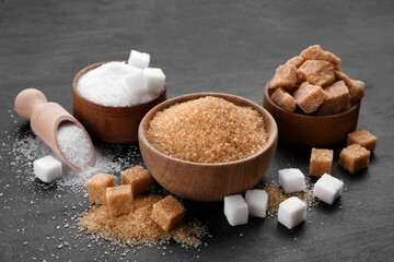 Different types of sugar on black table - obrazy, fototapety, plakaty