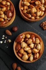 Tartlets with caramelized nuts on black table, top view. Delicious dessert
