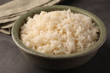 Delicious rice in bowl on grey table, closeup