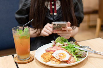 スマホで料理を撮影する女性