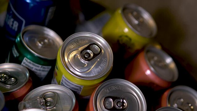 Tin cans with soda or beer stand in rows on the warehouse or supermarket shelf. Closeup shot. High quality 4k footage