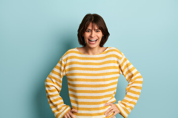 Cheerful Hispanic woman with hands on waist