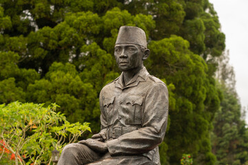 Indonesian Hero Statue Among Trees and Plants in Architectural Memorial Site