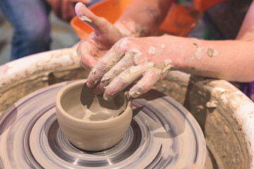 Pottery lesson master class for kids children, process of making clay pot on pottery wheel, potter wet hands creating ceramic crockery handcrafts, ceramist molding jar or vase