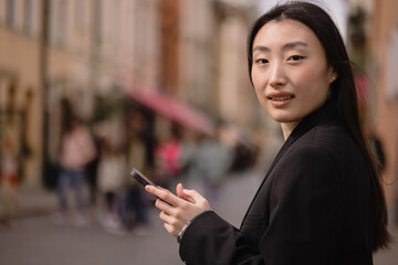 Portrait of a beautiful Korean woman. Asian woman in casual clothes talking on the phone, modern technology and lifestyle.