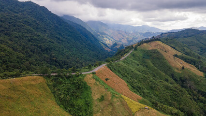 Fototapeta premium Shot from a drone camera angle at the Sky Road. Road 1256, Unseen Road, Nan Province, Thailand. It winds along the ridge of the forest. very beautiful view The rainy season will be green