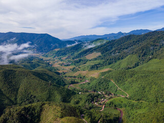 Drone shot at Sky Road, Huai Thon Village, Unseen Nan Village, Thailand, located in a complex valley, winding along the ridge of the forest. The view is very beautiful. The rainy season is green.