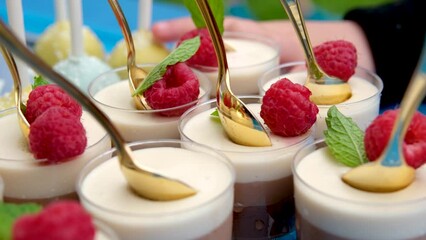 Delicious delicious desserts on the buffet. raspberry jelly dessert with golden teaspoons finger child chooses which one he wants