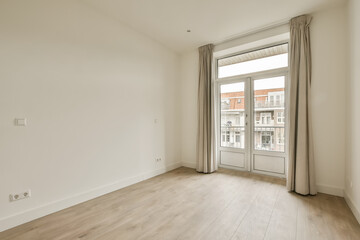 an empty room with wooden floors and white walls, there is a large window overlooking the cityscapea