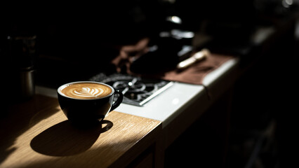 Cup of coffee with latte art on the wooden table.