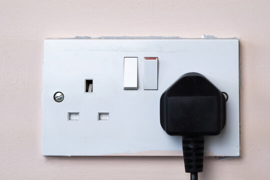 close up of english socket in the wall, electricity bills
