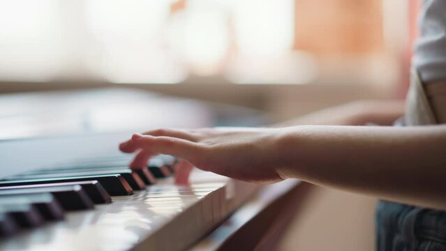 Girl with limited mobility learns new melody playing piano