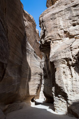 View of the Siq, the main entrance to the ancient Nabatean city of Petra in southern Jordan. This dim and narrow gorge culminates in a stunning sight, the iconic Treasury of Petra, Al Khazneh