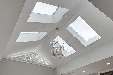 Obraz premium Minimal Bright Modern Skylight Vaulted Ceiling with Silver Metal Double Box Chandelier in Luxury Interior