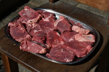 plate with red meat thawing in the sun