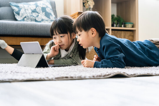 タブレットを見る日本人姉弟