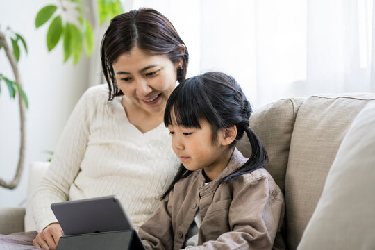 タブレットを見る日本人の母親と娘