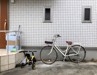 Bikes parked in front of a building with boxes on the front stoop