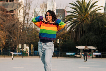 bella mujer andando en patines muy alegre sonriendo con polera de arcoíris estilo 80s 90s