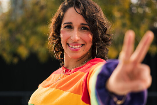 retrato de bella mujer latina con frenillos, polera de arcoíris estilo 80s 90s