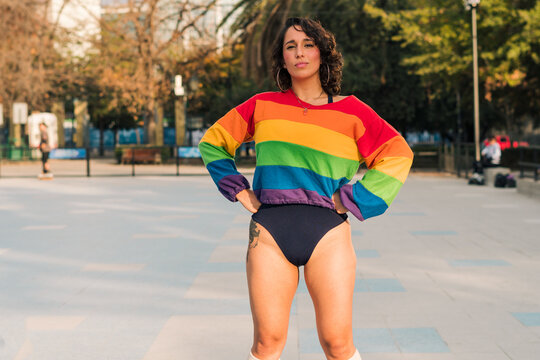 bella mujer latina andando en patines posando con bikini y polera de arco&iacute;ris estilo 80s 90s