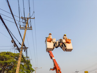 Electrician repairing cable on a power pole with electric repair service truck Internet phone back...
