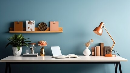 Image of Creative Workspace Desk with office accessories, blank photo frame or poster, book, plant on blue background. Mockup Space, Home Office Desktop Workspace. telephoto lens studio lighting
