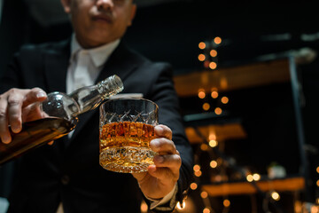 Businessman sitting Holding a Glass of Whiskey Drink Whiskey in the liquor store room
