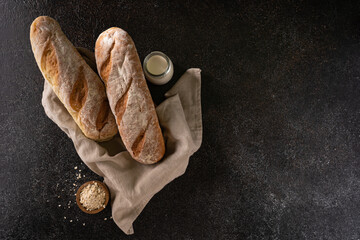 Fresh homemade artisan loaf of baguette breads on rustic background with copy space. sourdough mini...