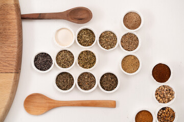 especias con vista cenital en tapas redondas acomodadas, con cucharas de madera 