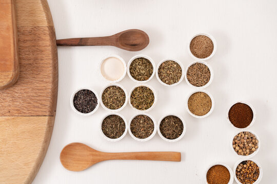 especias con vista cenital en tapas redondas acomodadas, con cucharas de madera 