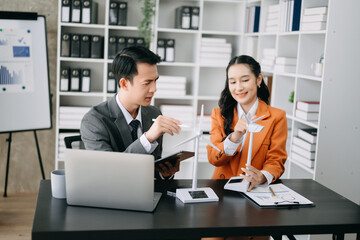 Alternative energy engineer pointing to a solar power panel and discuss with  business colleague team for the future power in the office.