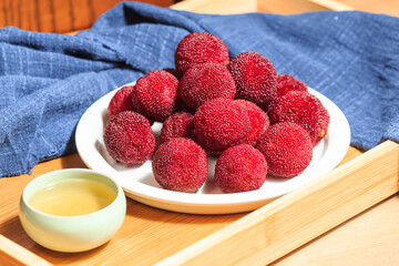 Fresh arbutus and a cup of tea in a bamboo tray