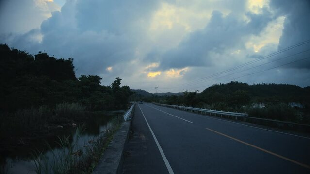 A road on an island in the Philippines with a Tuktuk approaching