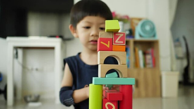 little boy build a city from many colorful wooden blocks, creative toy for design