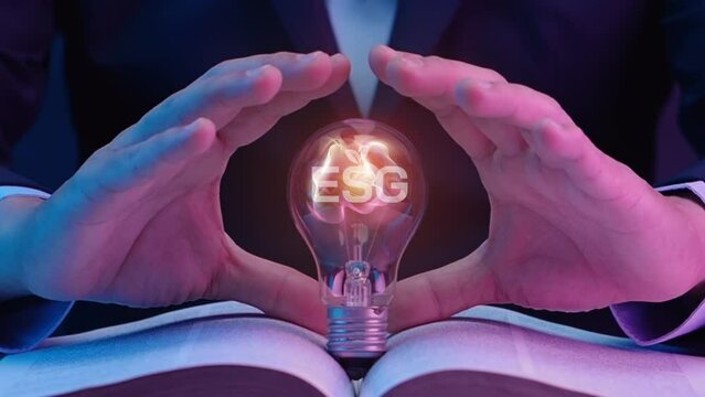 Businessman showing light bulb with ESG icons and virtual tree. Net zero greenhouse gas emissions target. Climate neutral long term strategy. Ecological, renewable energy and save environment concept.