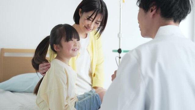 入院している女の子を診察する医師　小児科医