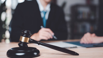 Wooden judge gavel on table ,justice in punishment of offenses and criminal verdicts ,concept of law and justice ,Lawyer or judge examining documents ,legal contract consulting ,court proceedings