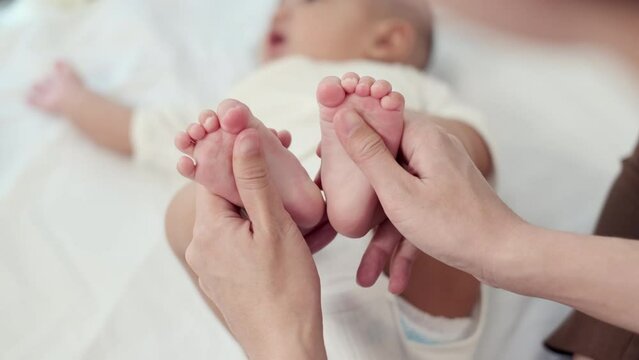 Selective focus, Baby foot massage for stimulate development by mother. Mother makes massage for happy baby. Infant healthcare concept.