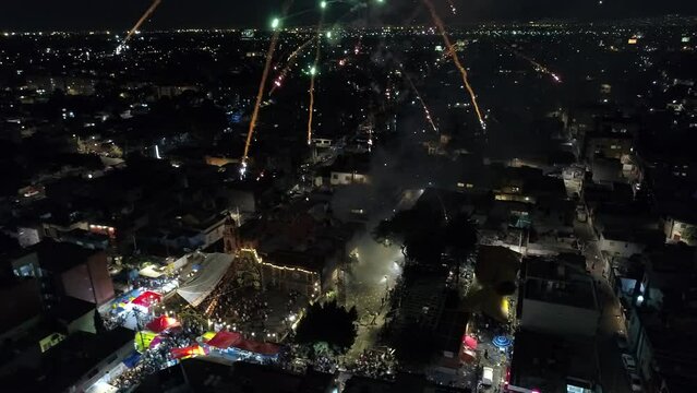Spectacular colorful fireworks exploding in the sky over a marquee at a local Mexico City festival. Aerial view at night