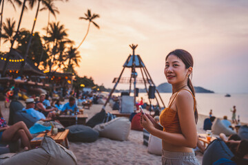 Traveler asian woman with mobile phone travel in beach club cafe Koh Kamui Thailand © Peera