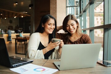 two women working on laptop computer